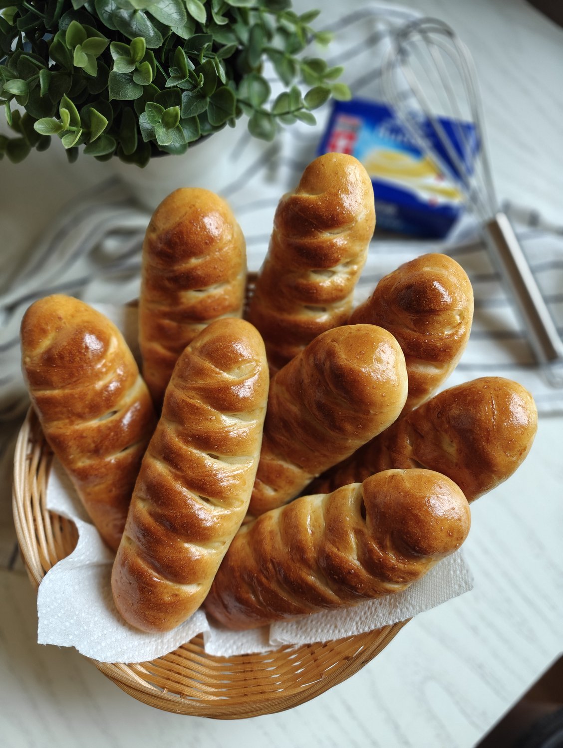 Hand-braided golden sausage rolls arranged in a wicker basket